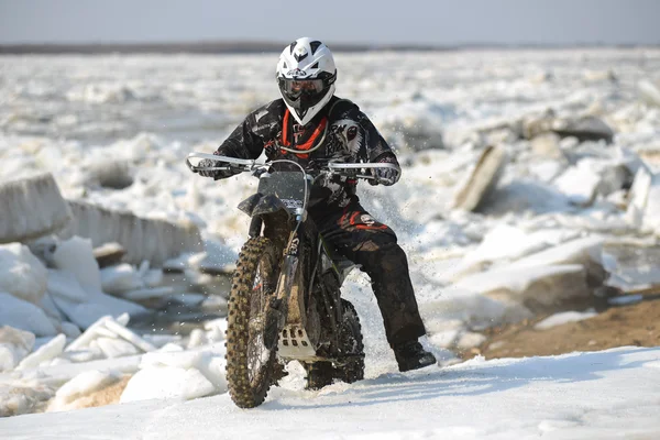 Enduro motorcycles are riding on rastasia ice on the river