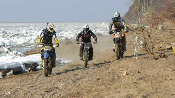 Enduro motorcycles are riding on rastasia ice on the river
