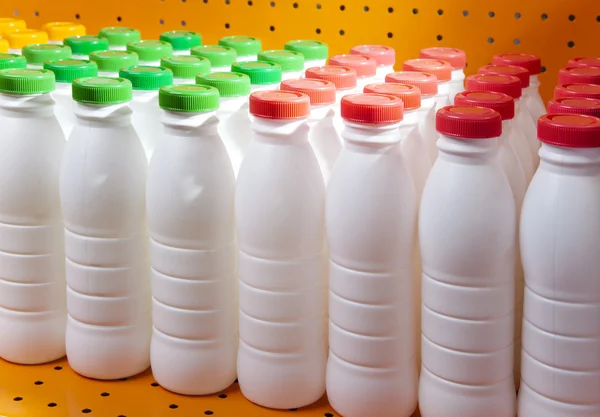 Dairy products bottles with bright covers on a shelf in the shop