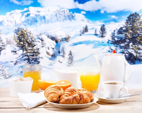 Breakfast with coffee and croissants over winter landscape