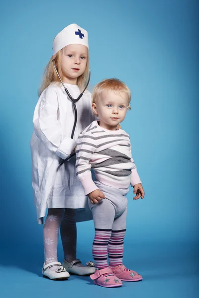 Two cute little girls playing doctor