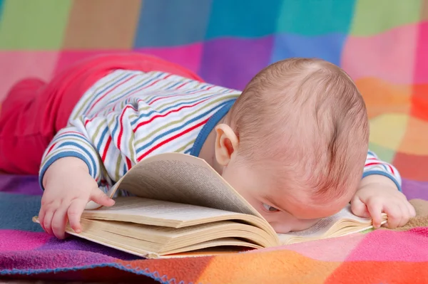 Baby reading book on colorful background