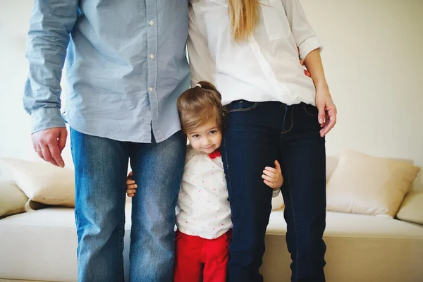 Girl hugging mom and dad for legs
