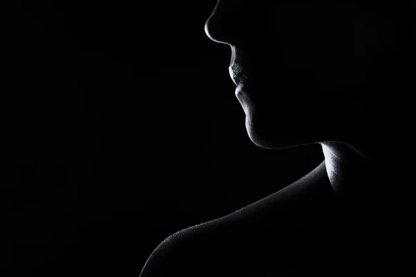 Silhouette of a woman face in black and white rim lighting