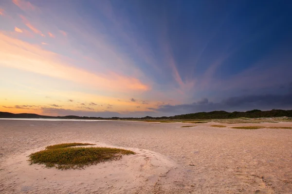 Cloudy sunrise over a quiet lagoon with cloud patterns and orang