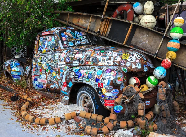 Old car covered with a variety of stickers