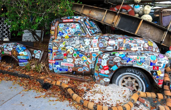 Old car covered with a variety of stickers