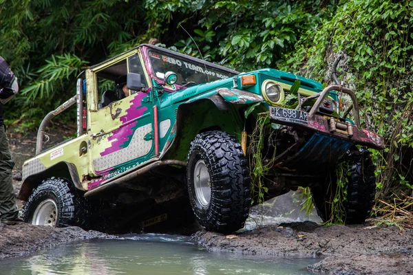 SUV in the tropical jungle - March 7, 2013 Adventure car enthusiast wading a rocky river  using modified four wheel car