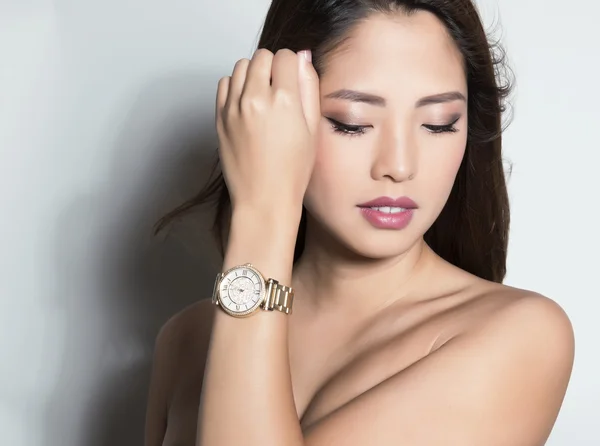 Beautiful young asian woman posing with wrist watch