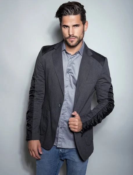 Handsome young man in suit on grey background