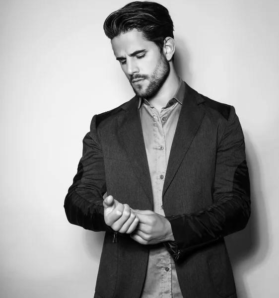 Handsome young man in suit on grey background