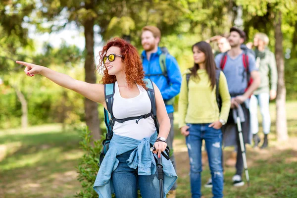 Girl in group of hikers pointing somethin