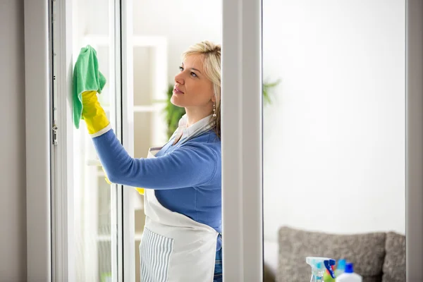 Diligent woman cleans window