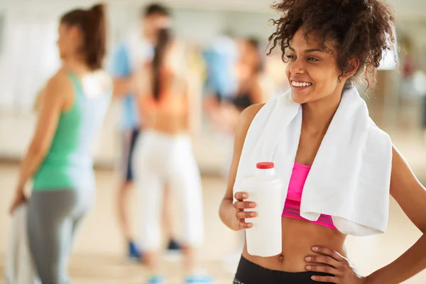 Half-caste girl with protein shake after training