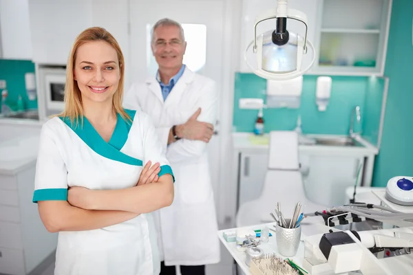 Portrait of dental assistant with dentist in dental clinic