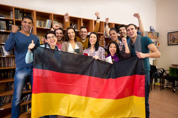Students with hands raised and smiling faces present German country