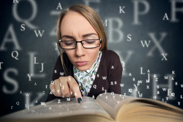 Girl reading a book with letters coming out of the book