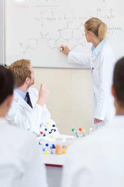 Chemical student write chemical formula on the blackboard