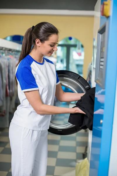 Employees putting clothes in the dryer
