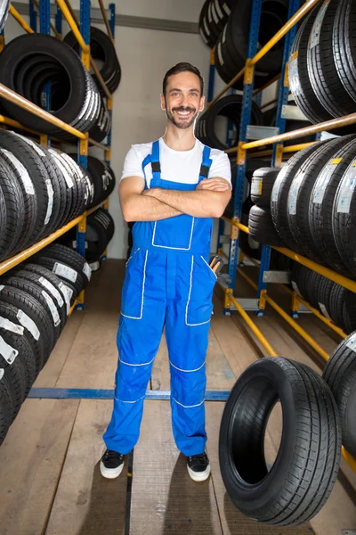 Mechanic standing between car tires