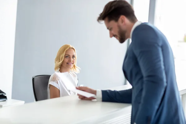 Female receptionist look at handsome businessman