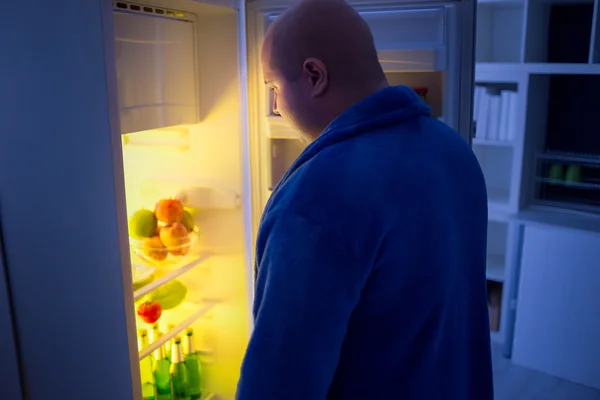 At night overweight guy open refrigerator