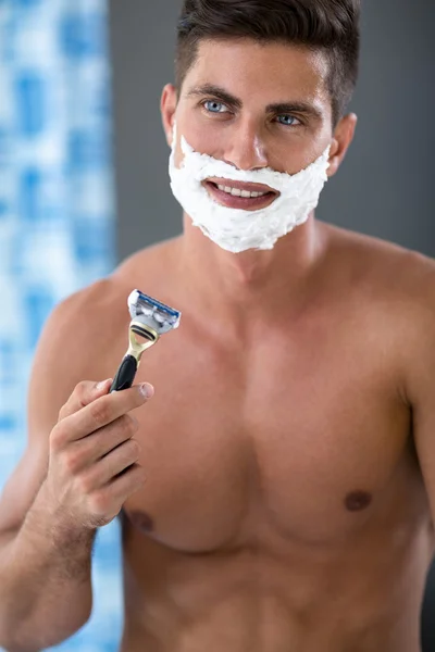 Young fit man with shave foam on face