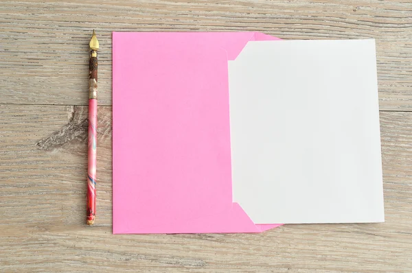 A pink envelope with a piece of paper sticking out