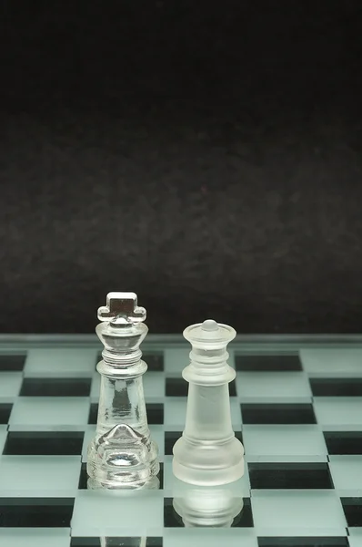 A king and queen chess pieces displayed on a chess board