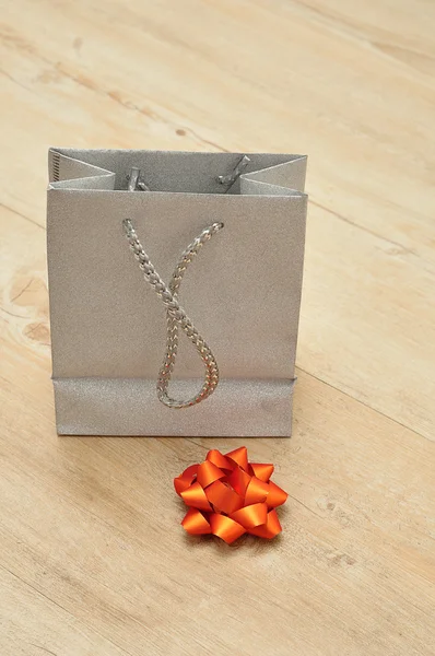 A silver gift bag with a bow