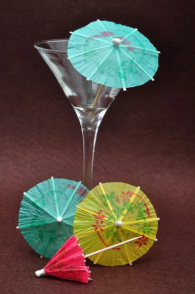 A martini glass displayed with cocktail umbrellas