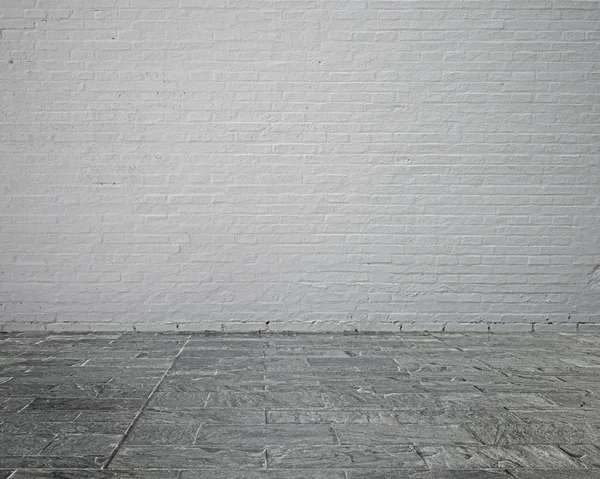 Empty room interior with brick wall and stone floor
