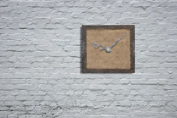 Old wooden board with clock hands on white bricks wall