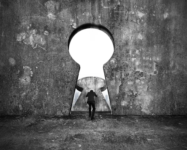 Businessman pushing keyhole door with city buildings view