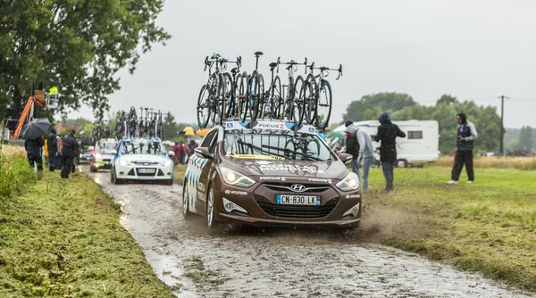Row of Technical Cars on a Cobbled Road - Tour de France 2014