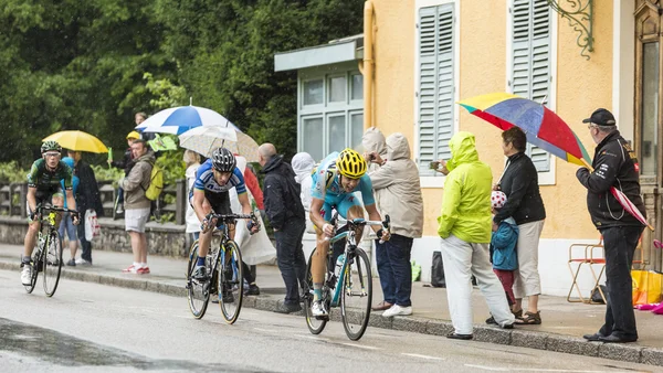 Three Cyclists Riding in the Rain