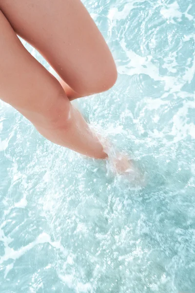 Close up view of nice woman legs in blue crystal clear water