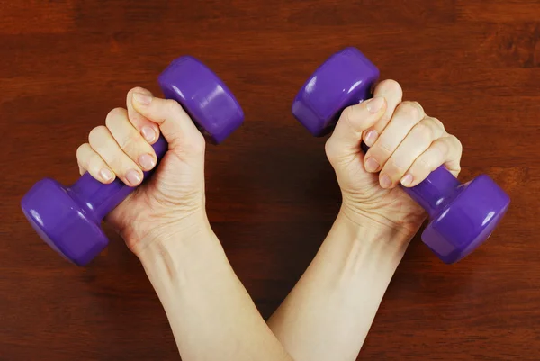 Hand of a young girl with dumbbells