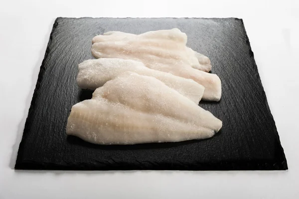 Frozen fish on a stone plate