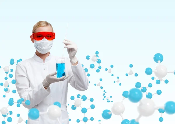 Young doctor in respirator holds a glass beaker on molecular compound background