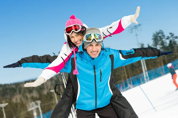 Happy couple of alpine skiers have fun