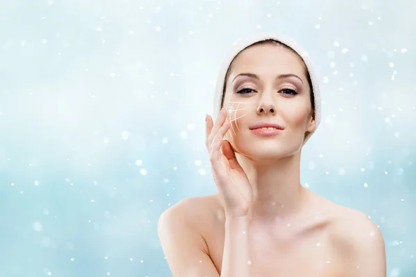 Woman making face moistening procedures in winter time