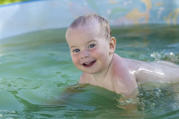Funny toddler happily swimming in the pool