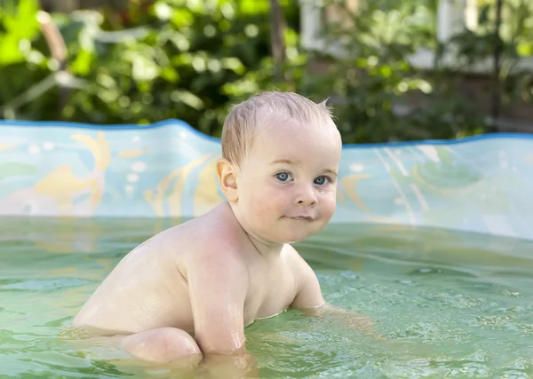 Funny toddler happily swimming in the pool