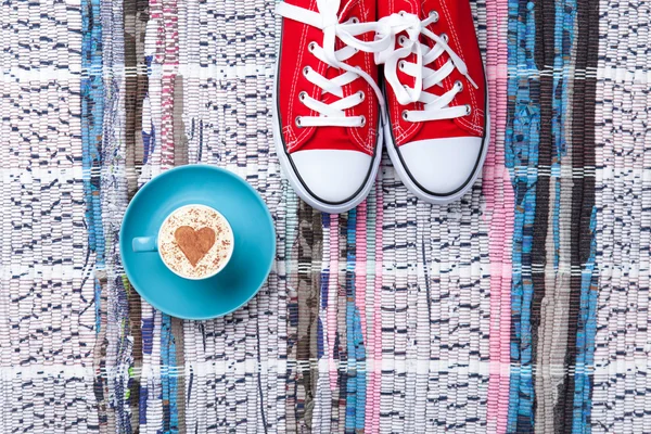 Cup and gumshoes on the table