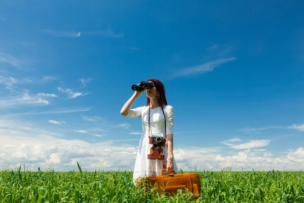 Young woman with suitcase and binocular