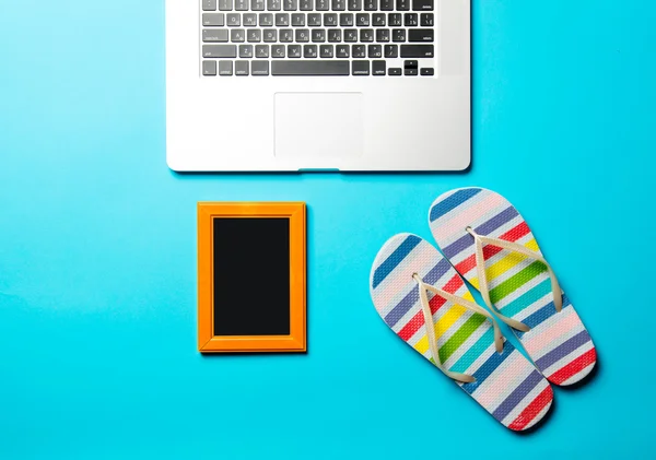 Flip flops , photo frame and laptop