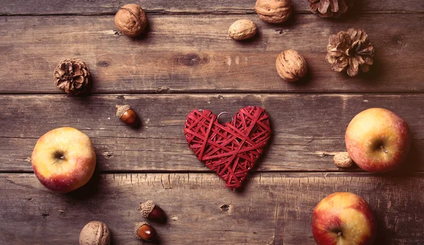 Apples, heart shaped toy, fir-cones and nuts