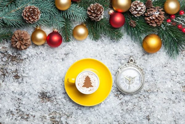 Cappuccino with christmas tree shape and clock on artificial bac