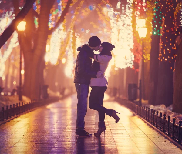 Couple kissing at night alley.